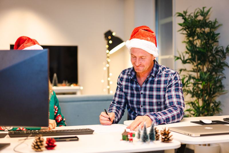 Colleagues in Santa hats in a decorated office
