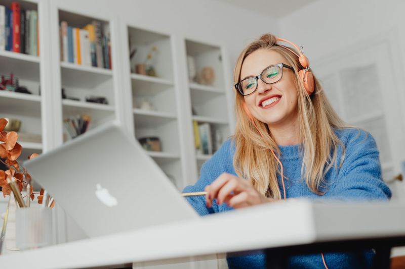 A smiling woman working on a laptop